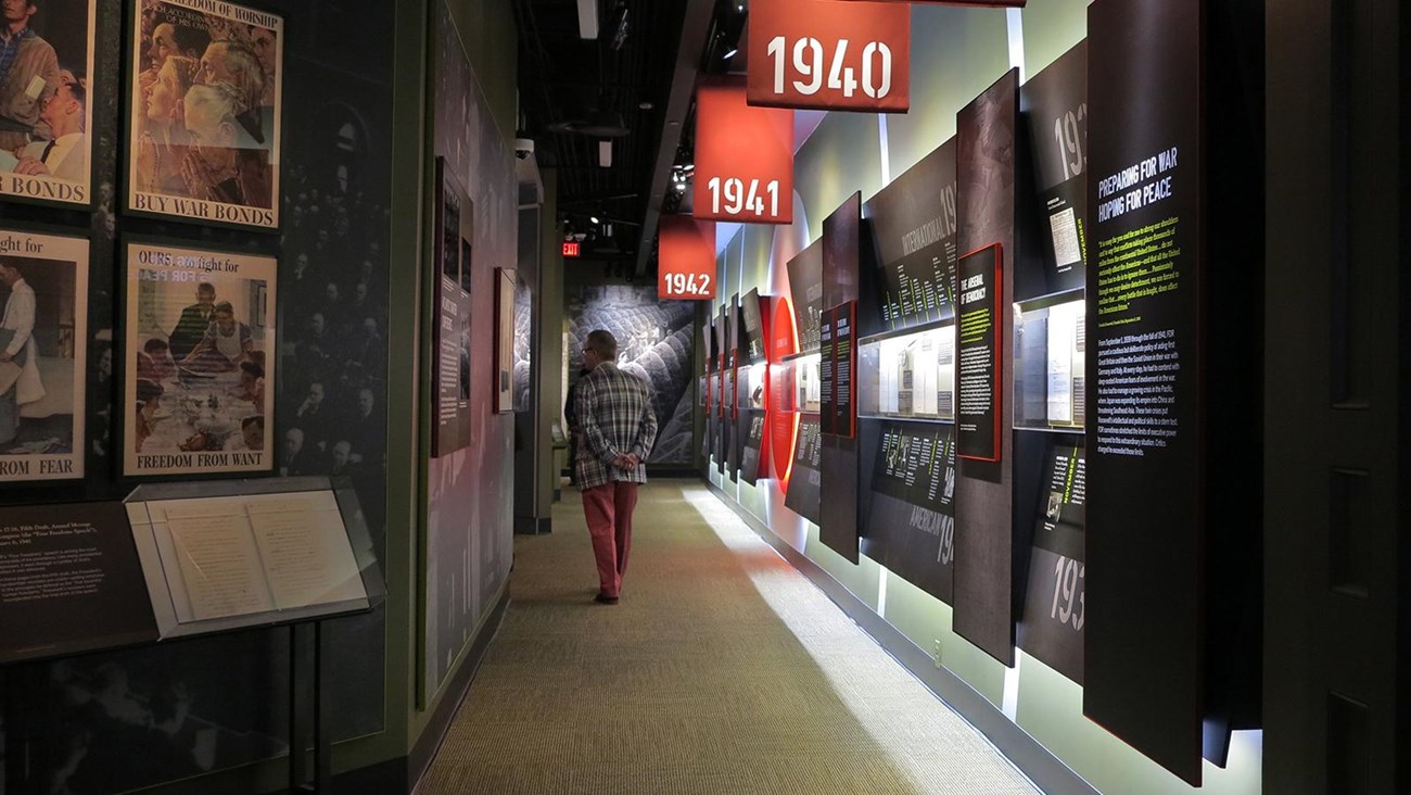 A passage with graphic panels, framed images, and exhibit cases.