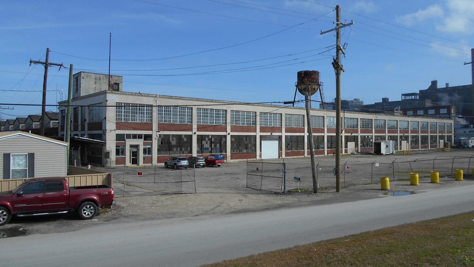 Exterior view of 2-story warehouse front façade with many bays showing. 