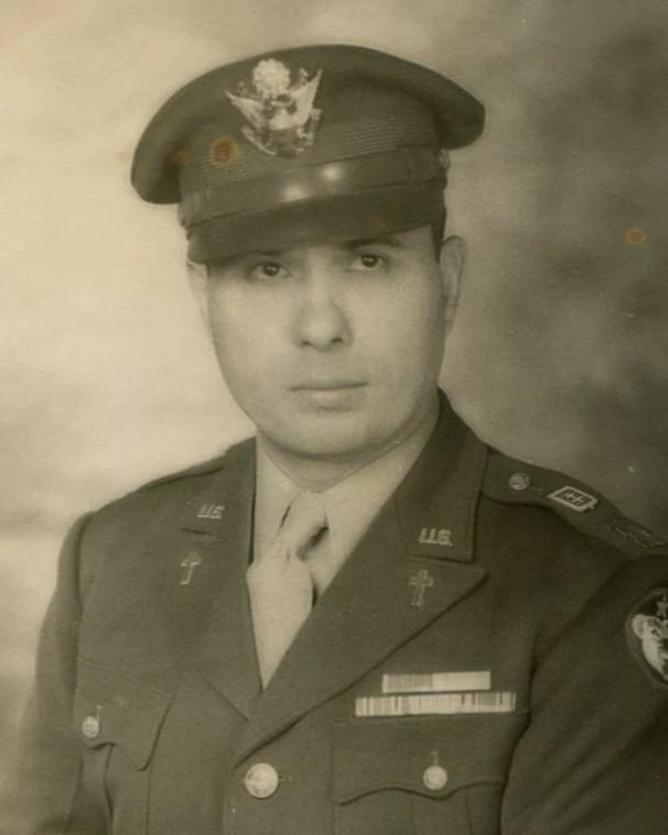 Portrait of a man in uniform with isgnia on jacket and a hat.