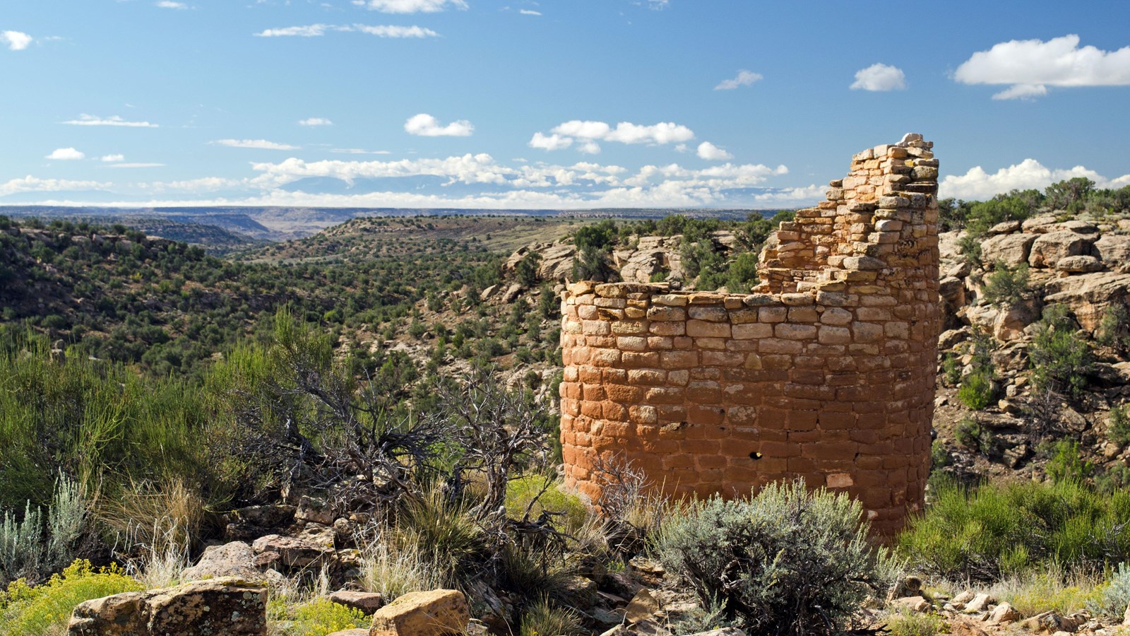 remains of a circular stone tower perched on the canyon rim, canyon country behind