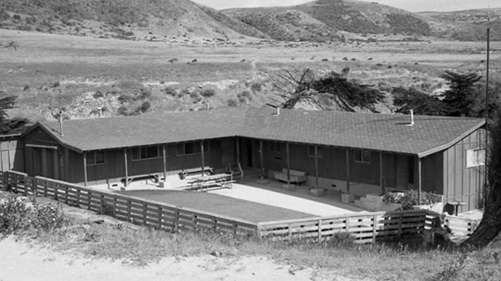 One story wood building with fence around it. 