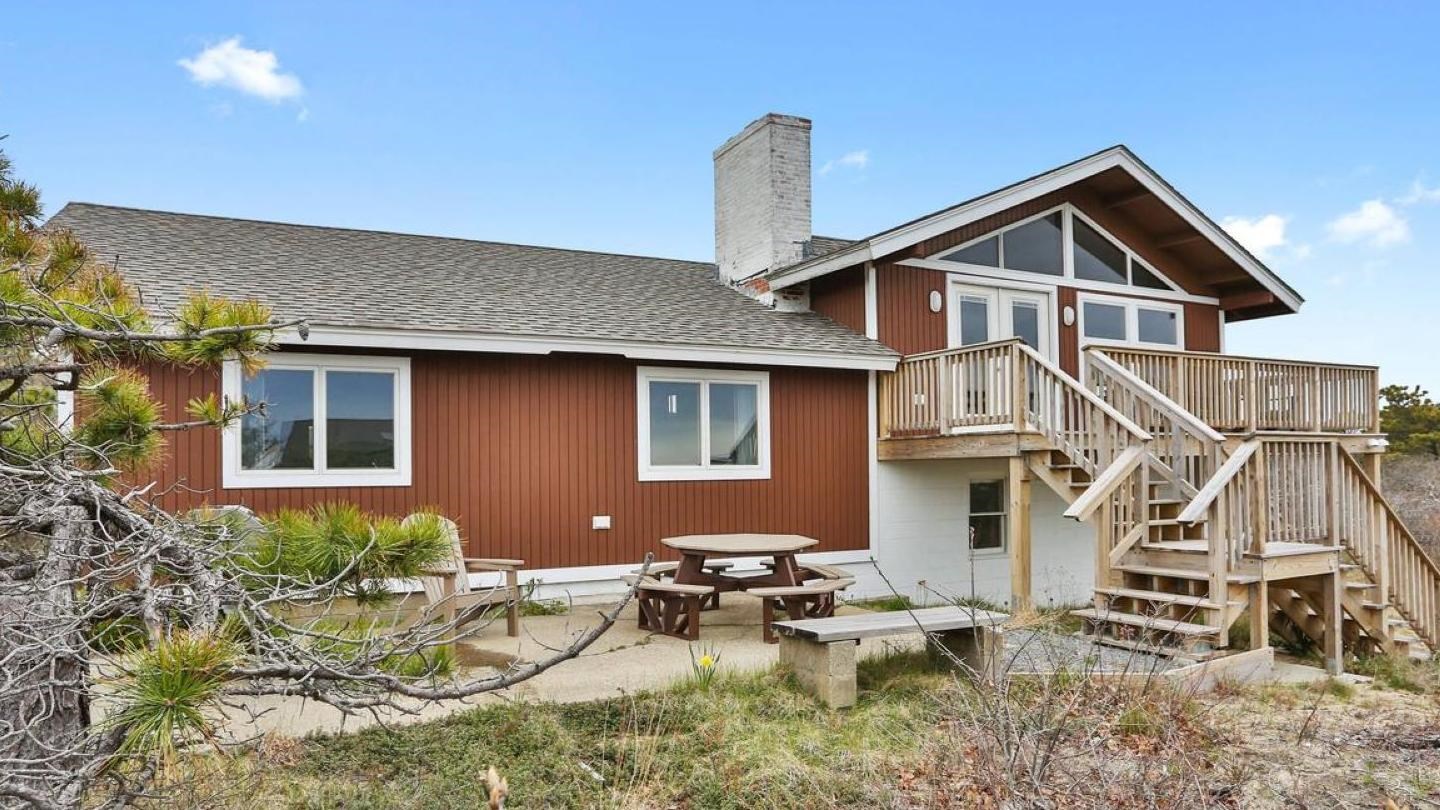 The Sunrise House is a brown, multi-level home that sits on a bluff overlooking the ocean.