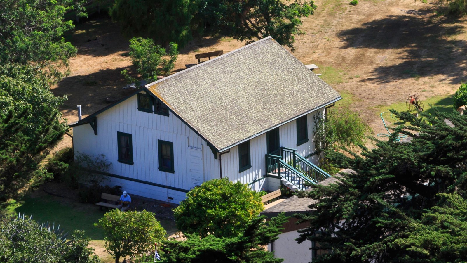 this one-and-a-half story wood frame structure has a simple, gable-roof and white board-and-batten s