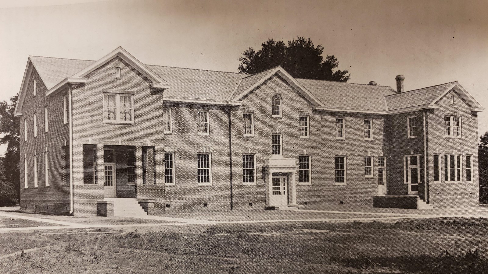 A large two-story brick building with long rectangular windows.