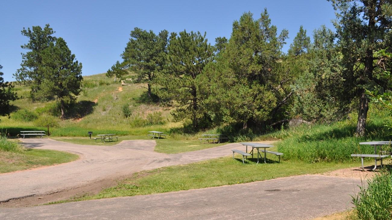 a picnic area with tables and several parking spots