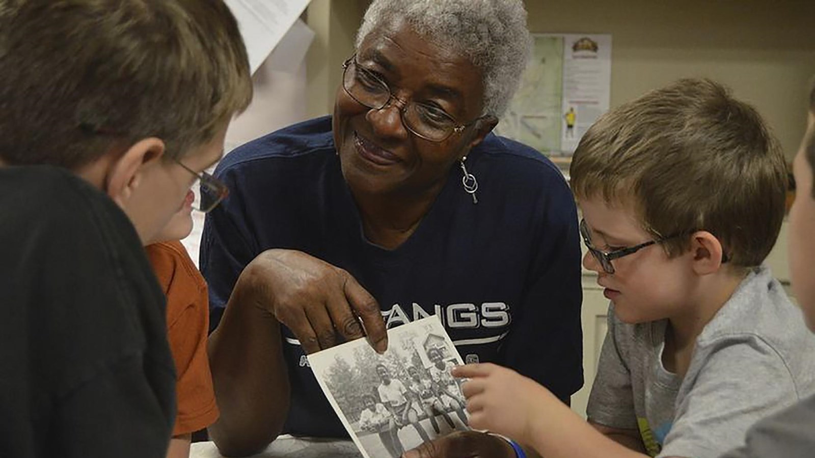 woman showing photographs to two young children