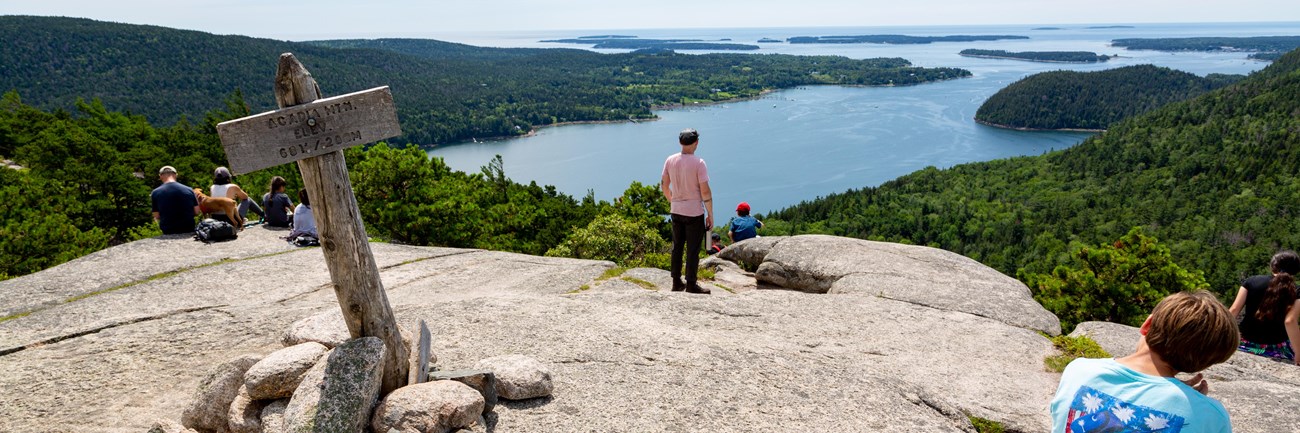 Visitors overlook islands from a mountain summit