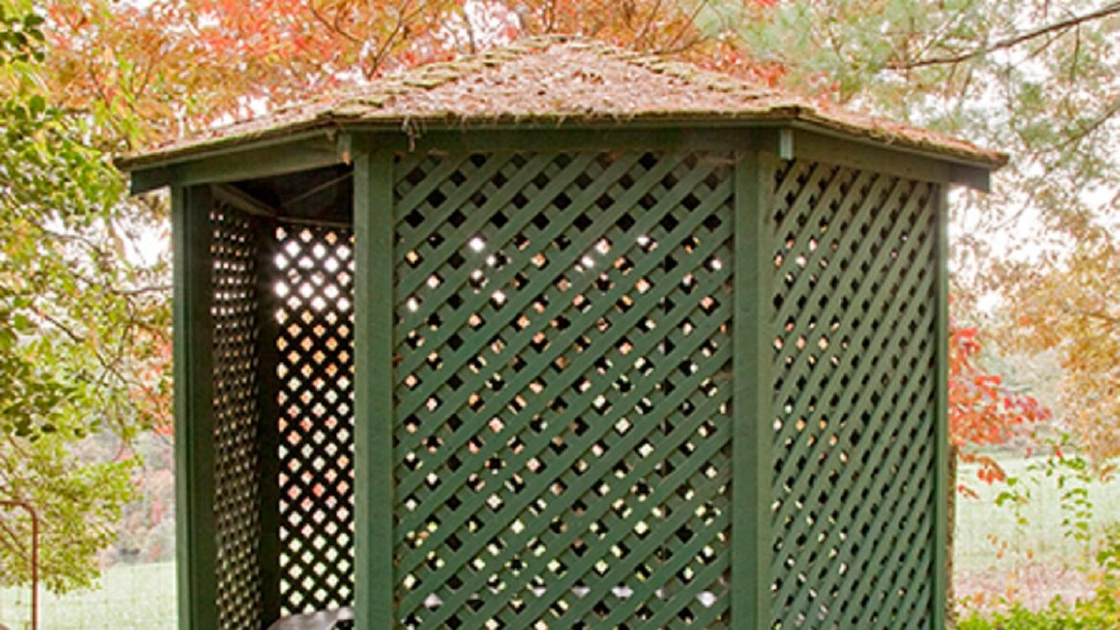 Green Lattice framed octagonal shaped open garden shed with inside benches