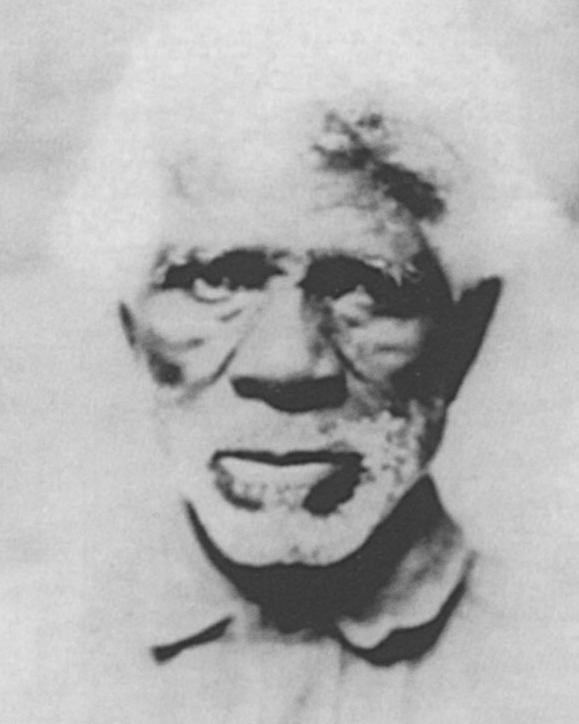 Black and white photo of African American man with white beard looking directly at the camera