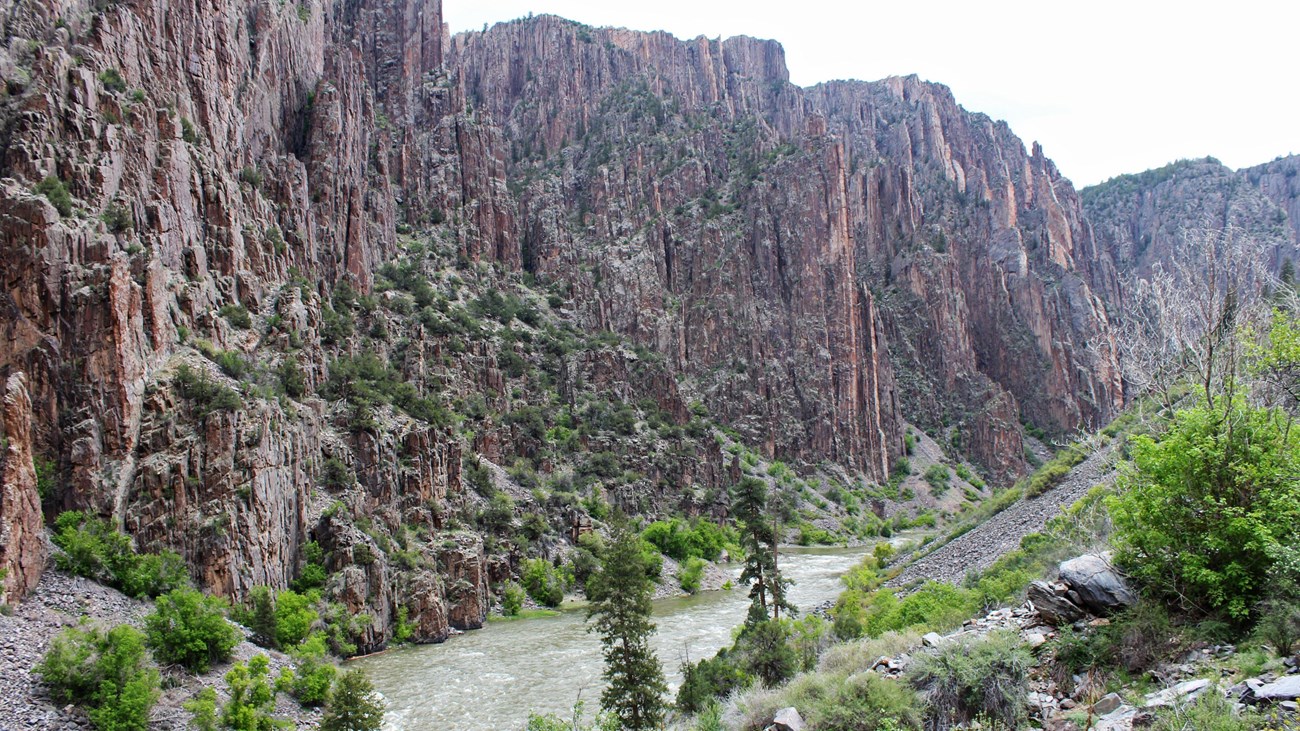 A view of a steep canyon and greyish river