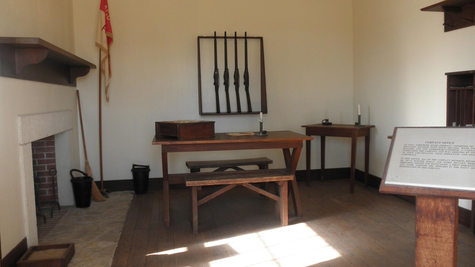 room with desks, a gun rack, and  a flag