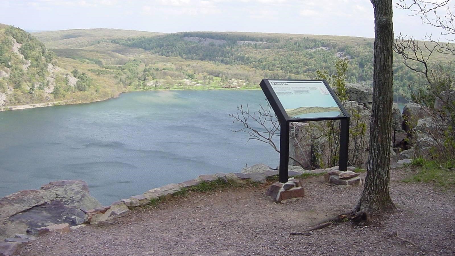 A viewpoint overlooks a lake and distant moraine that wrapped around high points in the landscape.