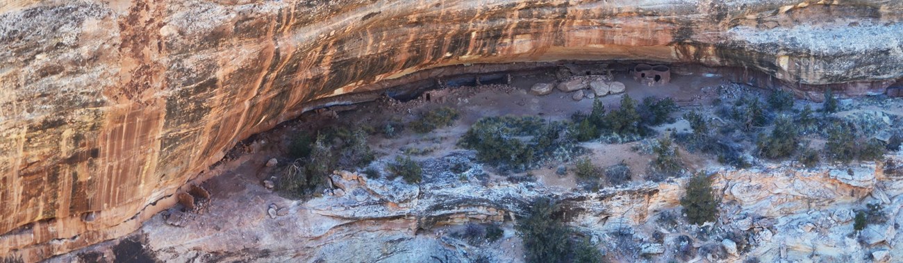 circular stone structures tucked into an alcove in the cliff-side