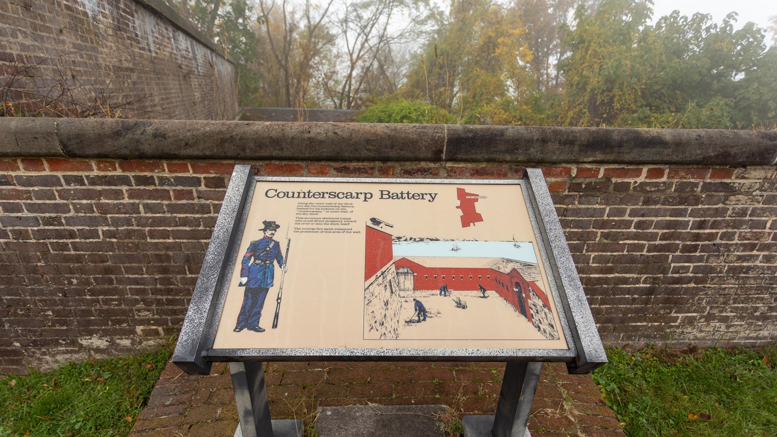 An information-panel in front of a brick wall, featuring text, a diagram, and two illustrations.