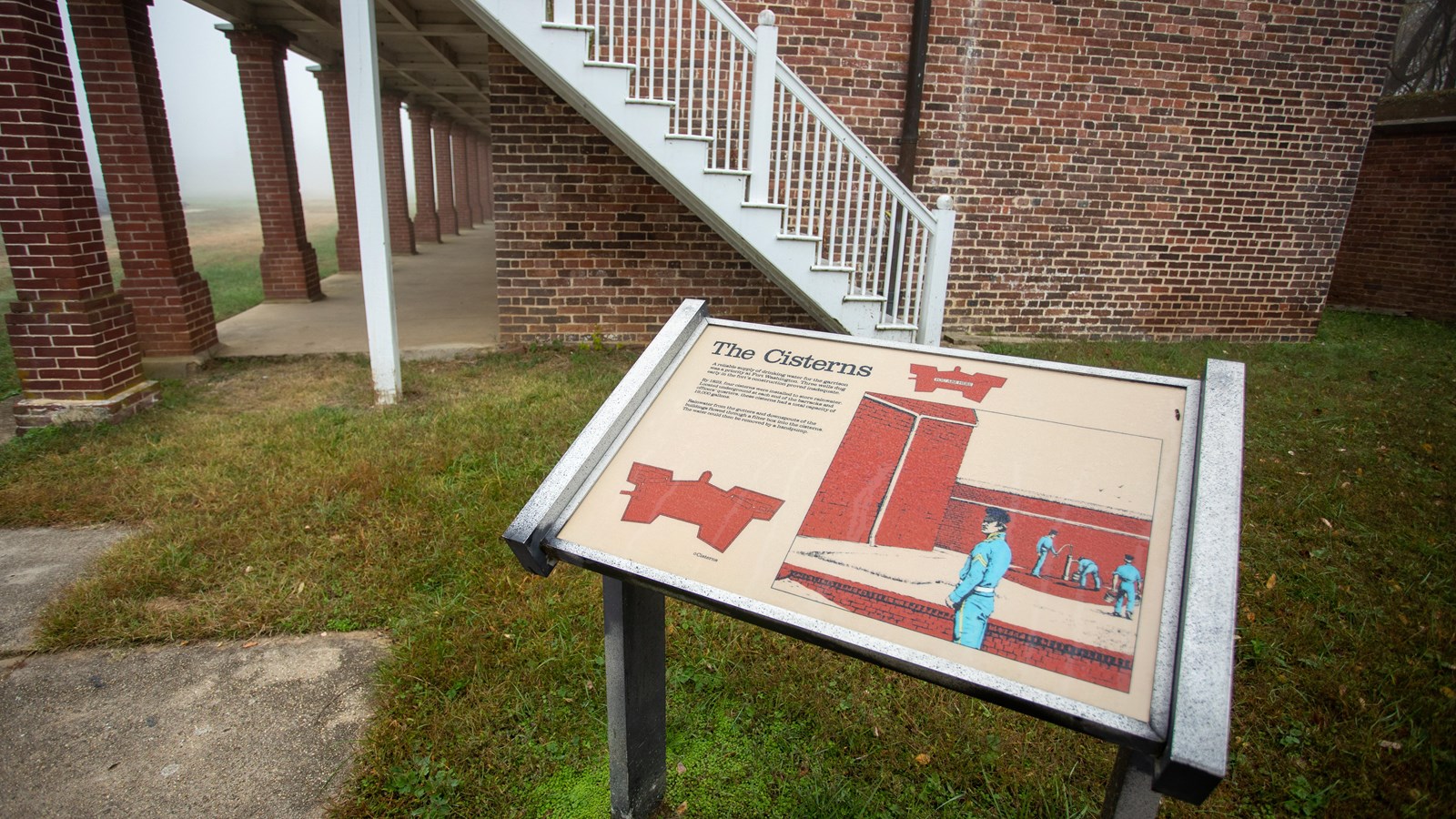 An information panel in front of a brick building, with text, two diagrams, and an illustration.