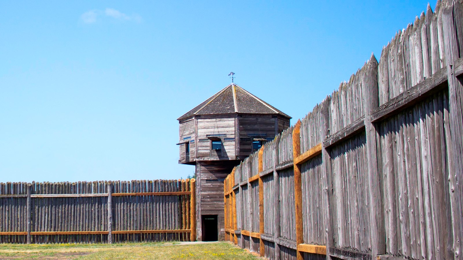 The three-story bastion tower at the corner of the fort\'s wooden palisade walls.