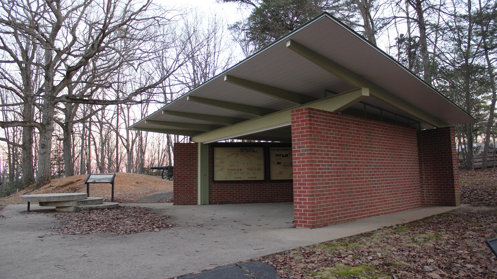 A brick pavilion atop a hill at sunset.