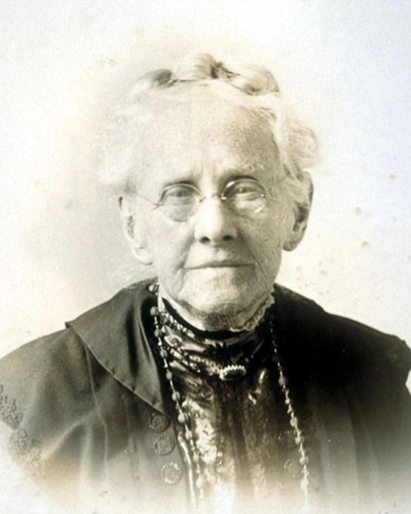Older white woman with graying hair wearing glasses. 
