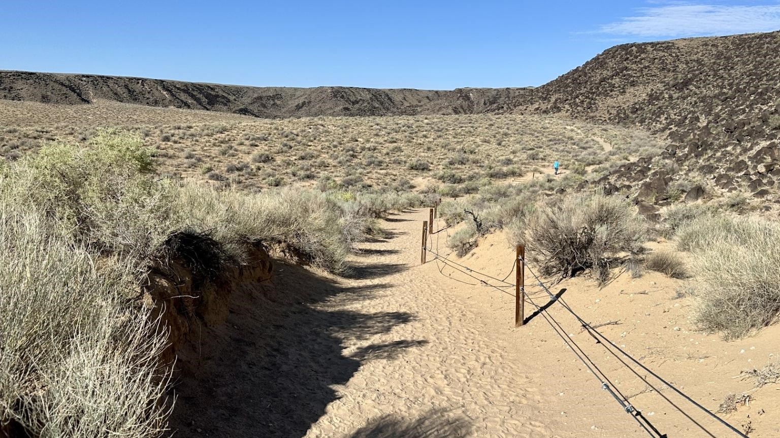 A sandy trail in a volcanic landscape.