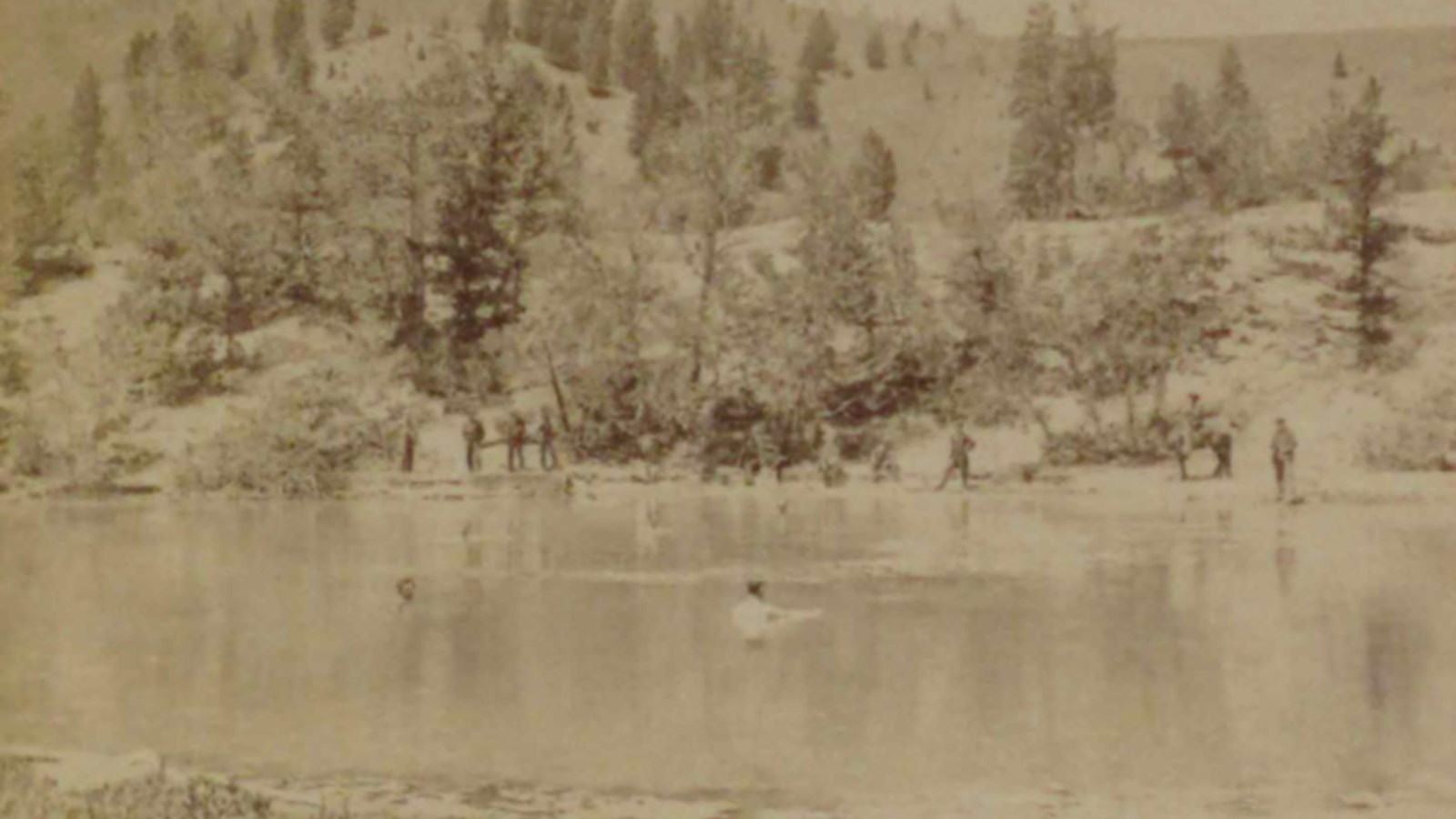 Historic photograph of men bathing in the hot spring while others watched.