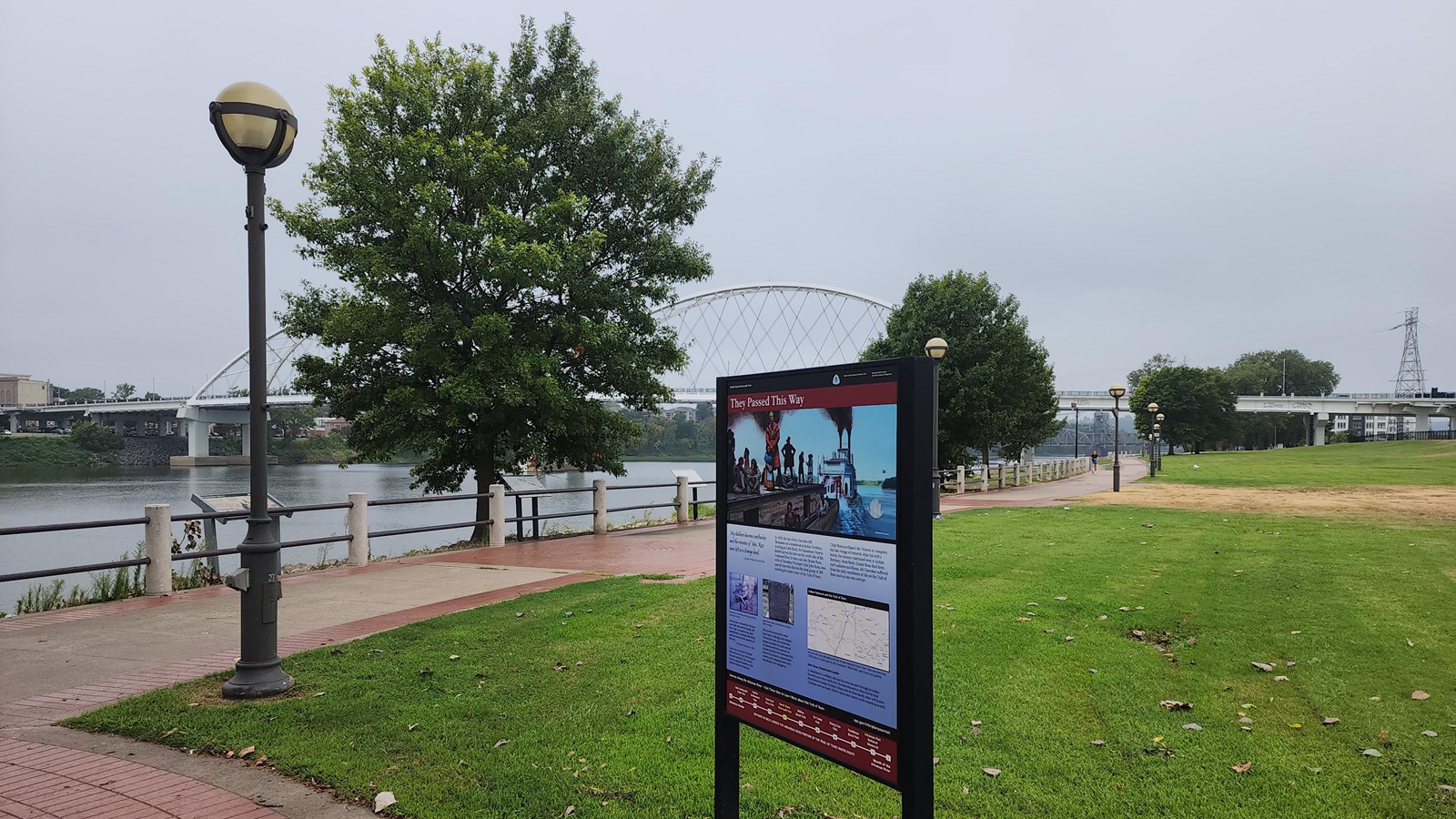 Pathway along the riverfront with Trail of Tears exhibit on the side and bridge in the background.