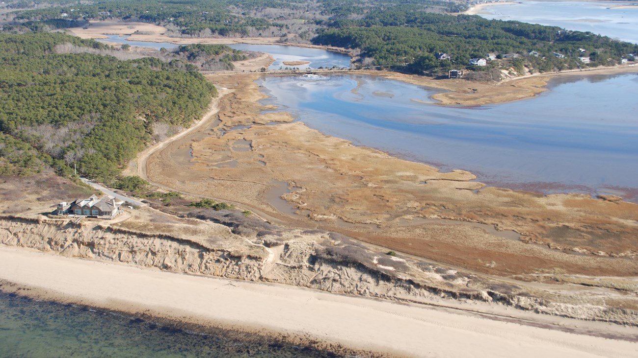 Aerial view of the start of the Great Island Trail, beach surrounded by ocean and a cove.