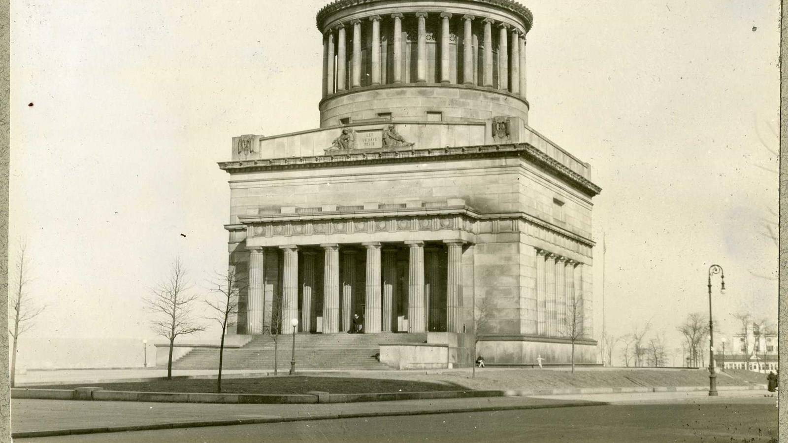 Black and white of large building with dome on top with grass in front