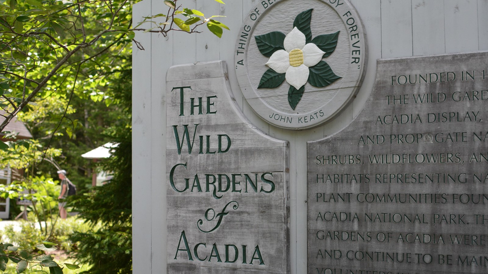 Grey sign with words and a flower design