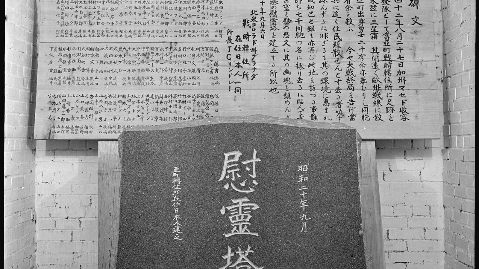 Historic image of a headstone and wooden panels with Japanese writing