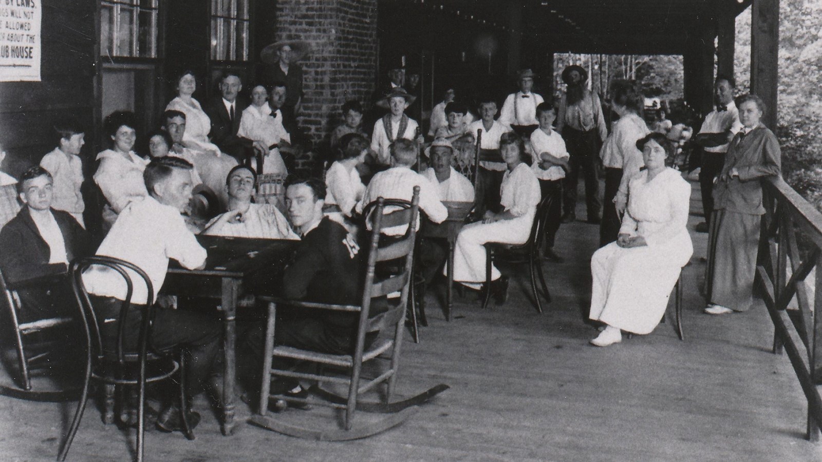 Black and white image of families gathered on the porch of the Appalachian Clubhouse.