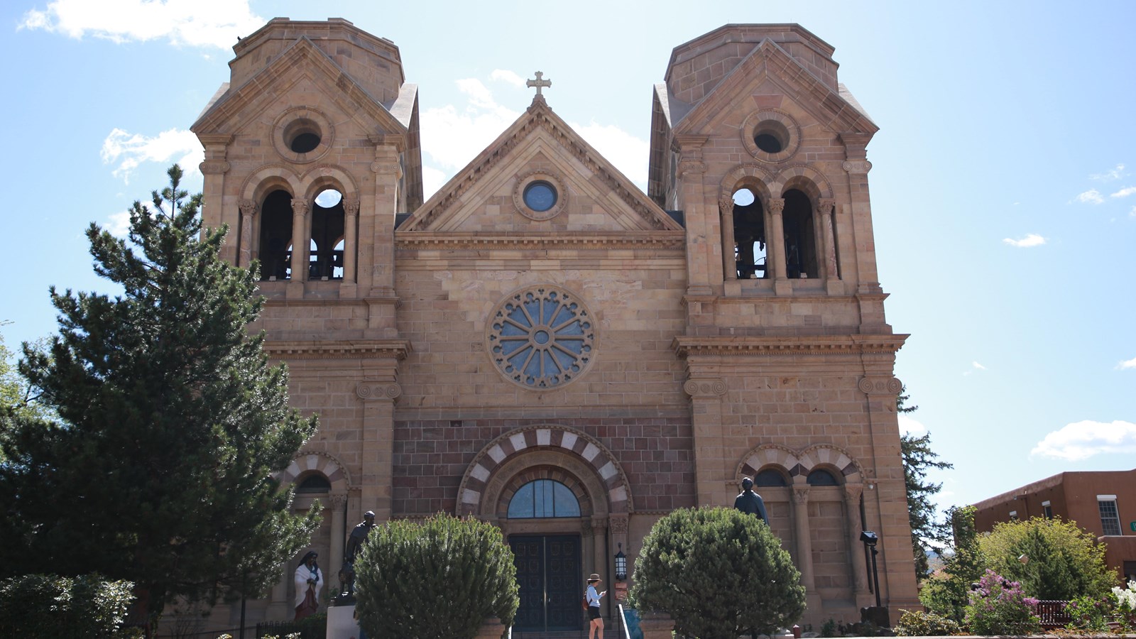 A large, stone, gothic-revival cathedral with two large bell towers.