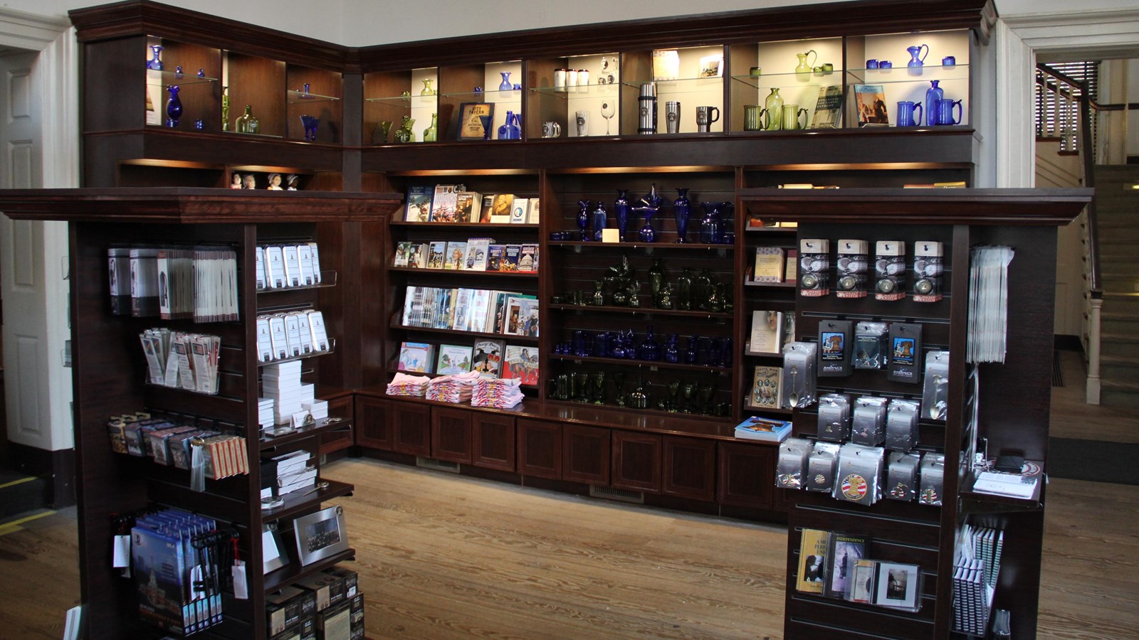 Dark colored wooden shelving units display a variety of books and souvenirs.