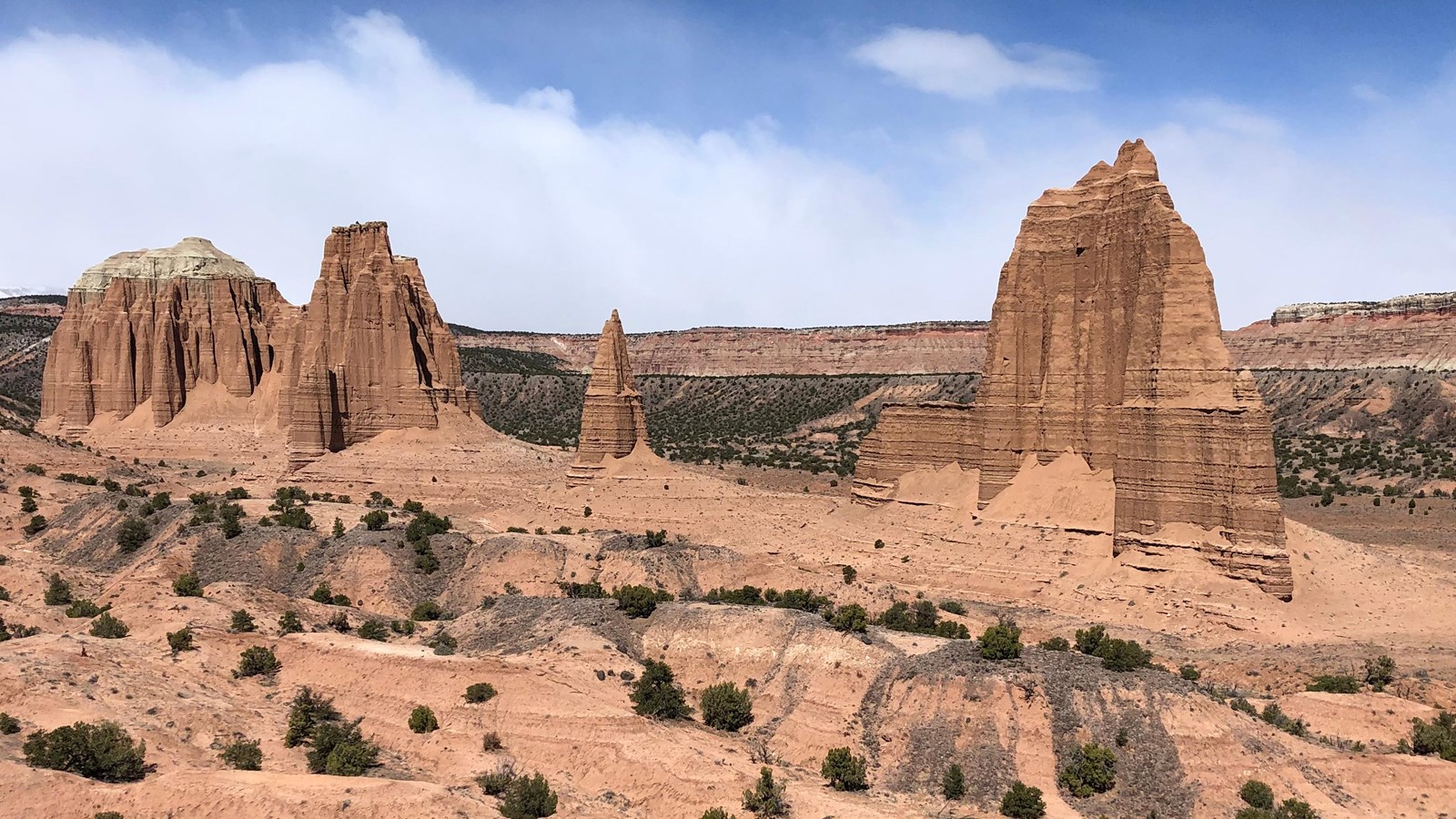 large reddish brown monoliths rise from the desert floor