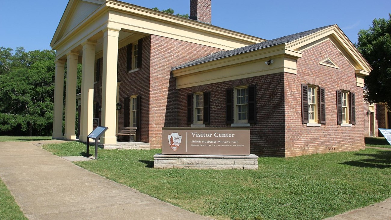 A large brick building with yellow columns. 