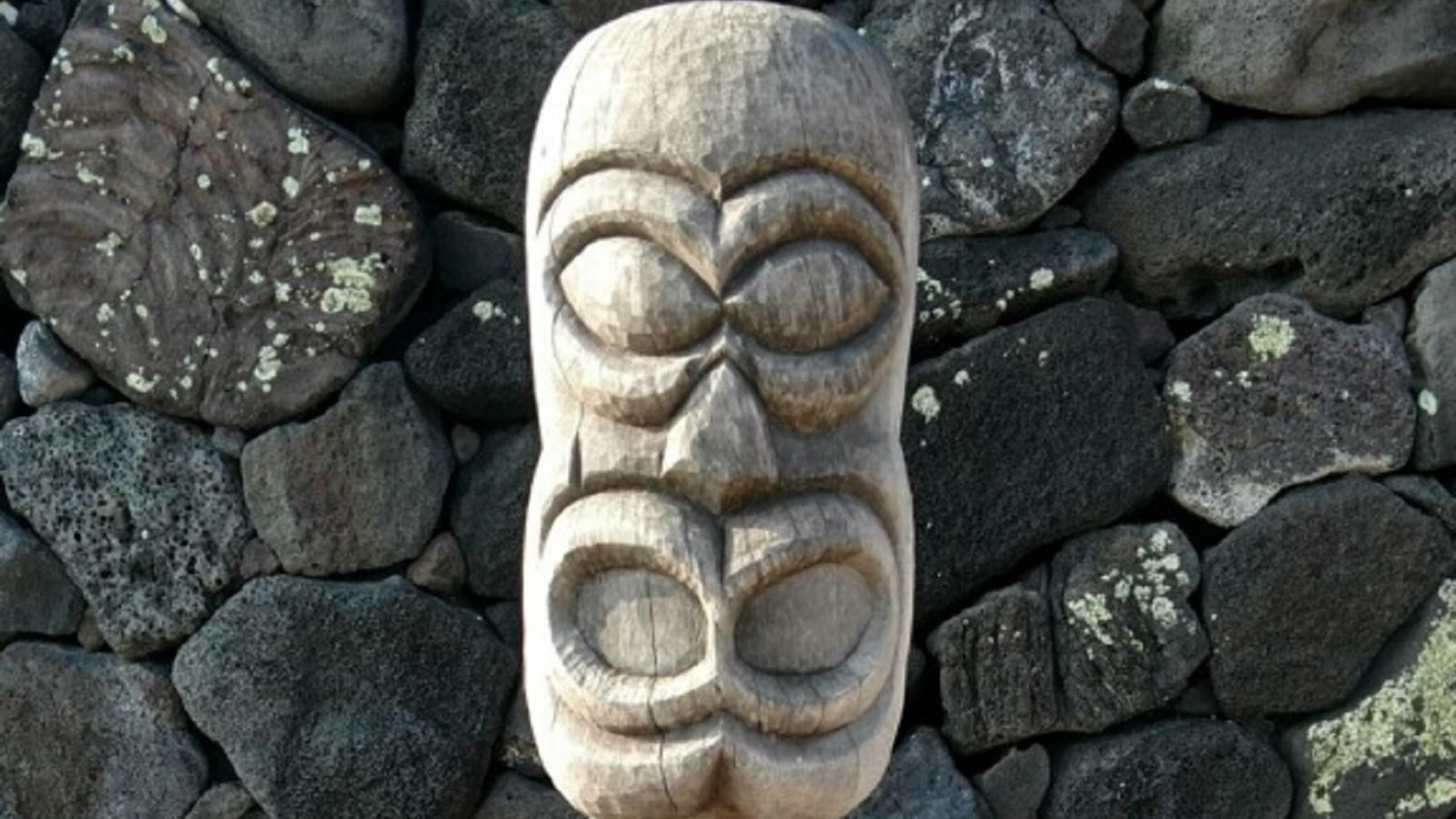 A four foot high kiʻi image with round oval eyes, open mouth, and bent-knee posture.