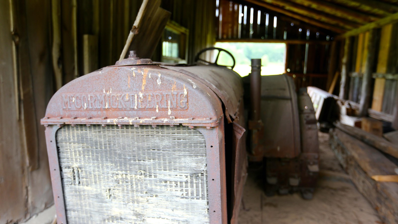 Metal, front grill of an old tractor inside of a wooden shed