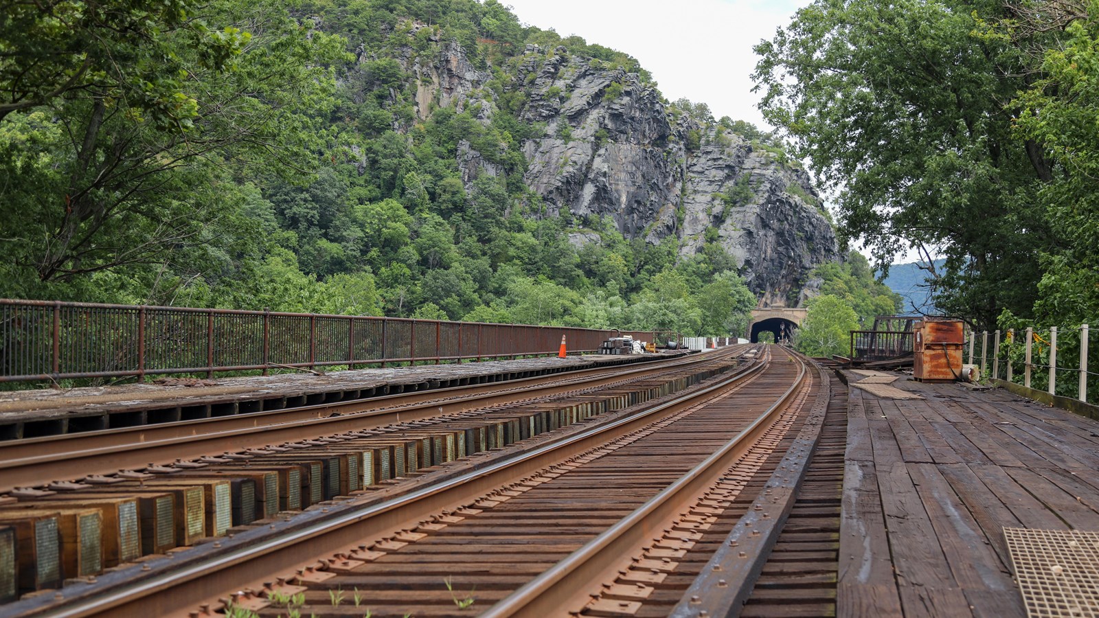 A railroad traveling across a bridge and through a tunnel.