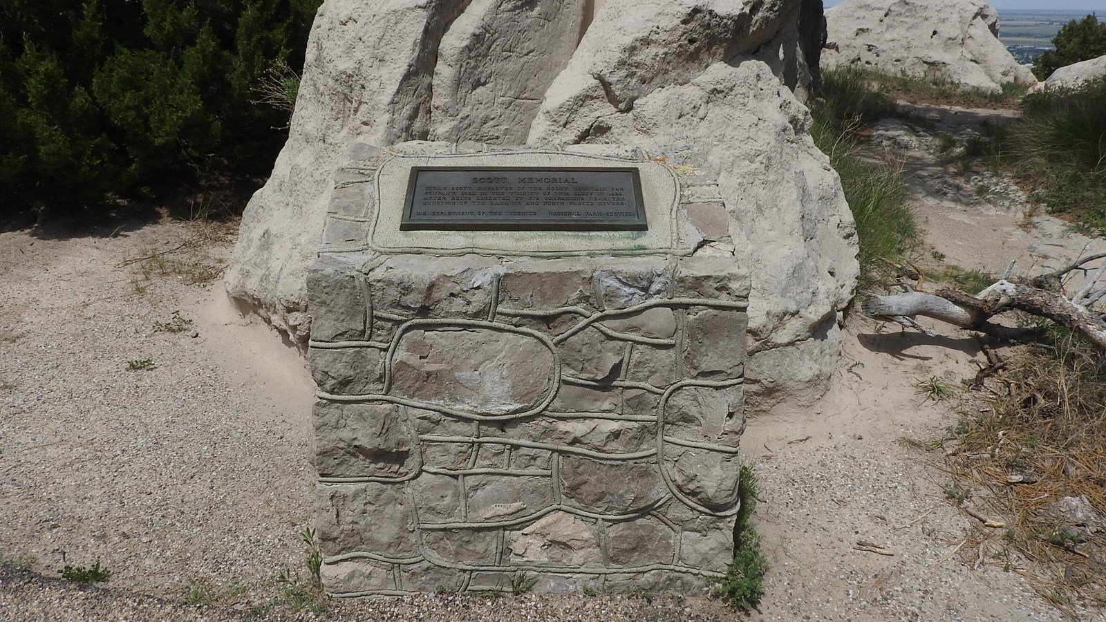 A metal plaque is set on a stone and mortar base. 