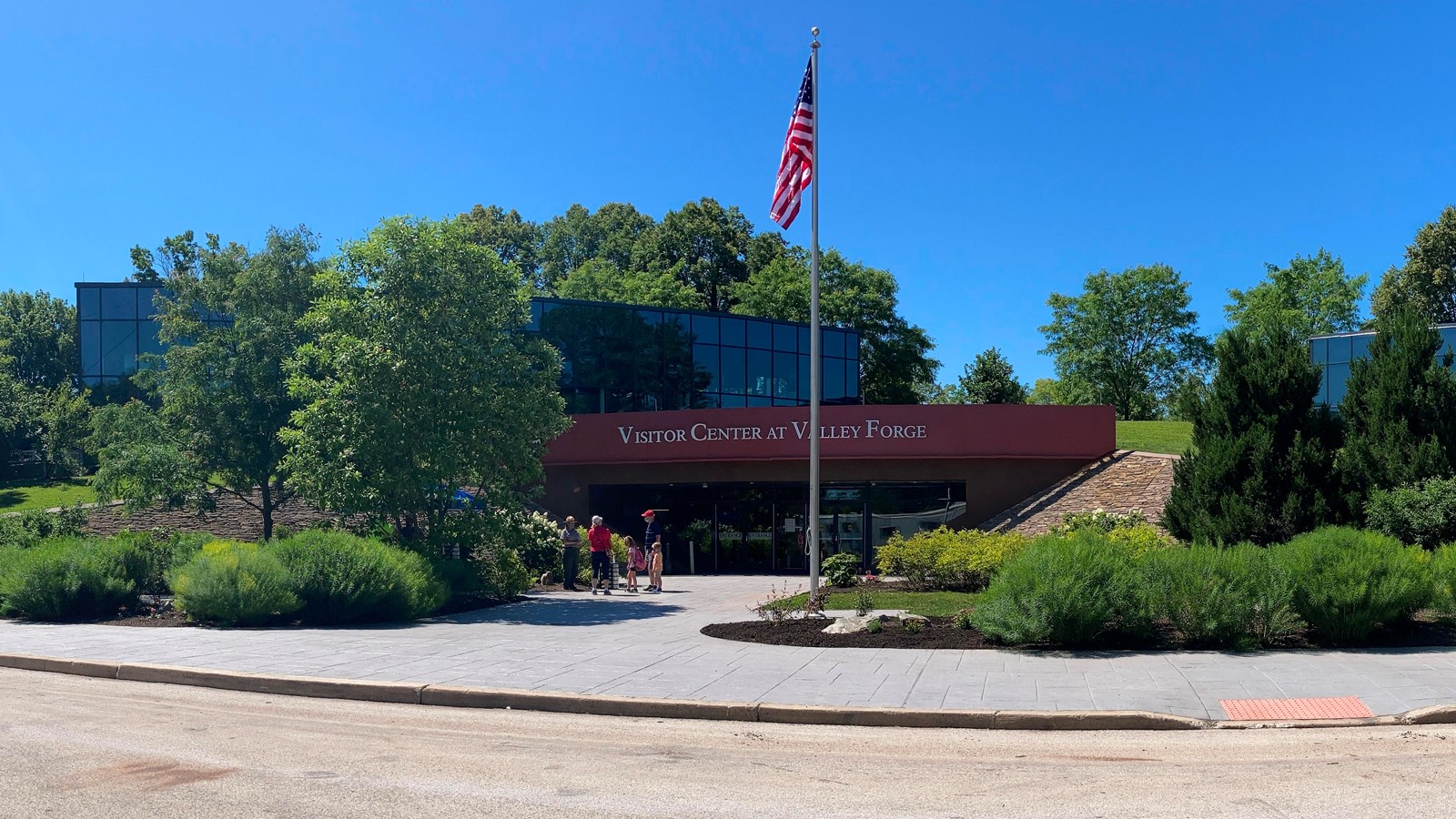 outdoors, flag, building, pavement, entrance doors