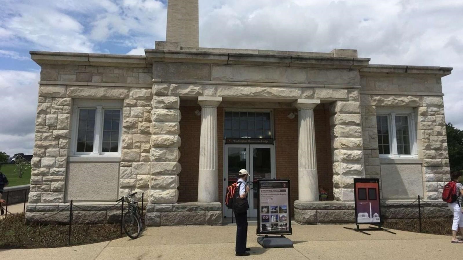 A small stone building in front of the Washington Monument