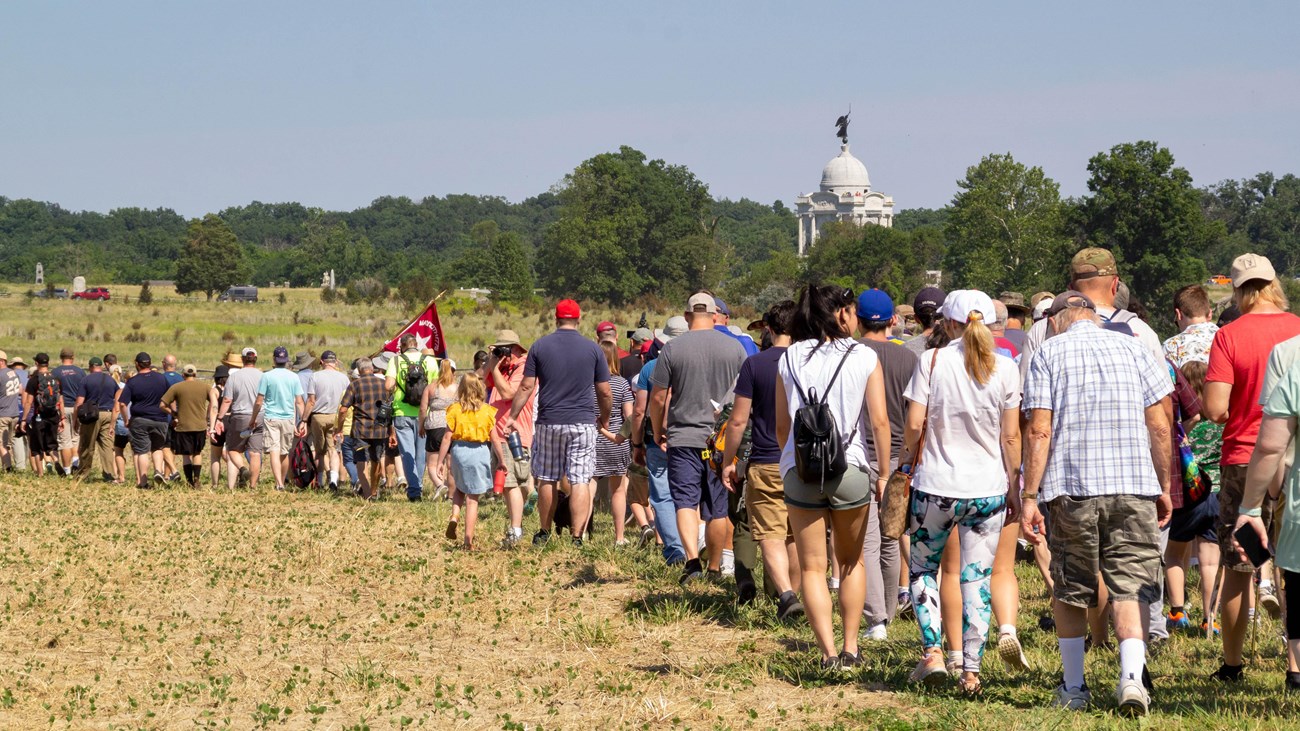 A large group of 200 people hike on a field.