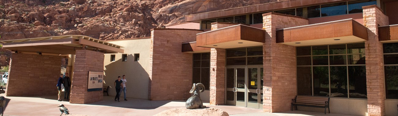 a red stone building with sculptures of animals in front