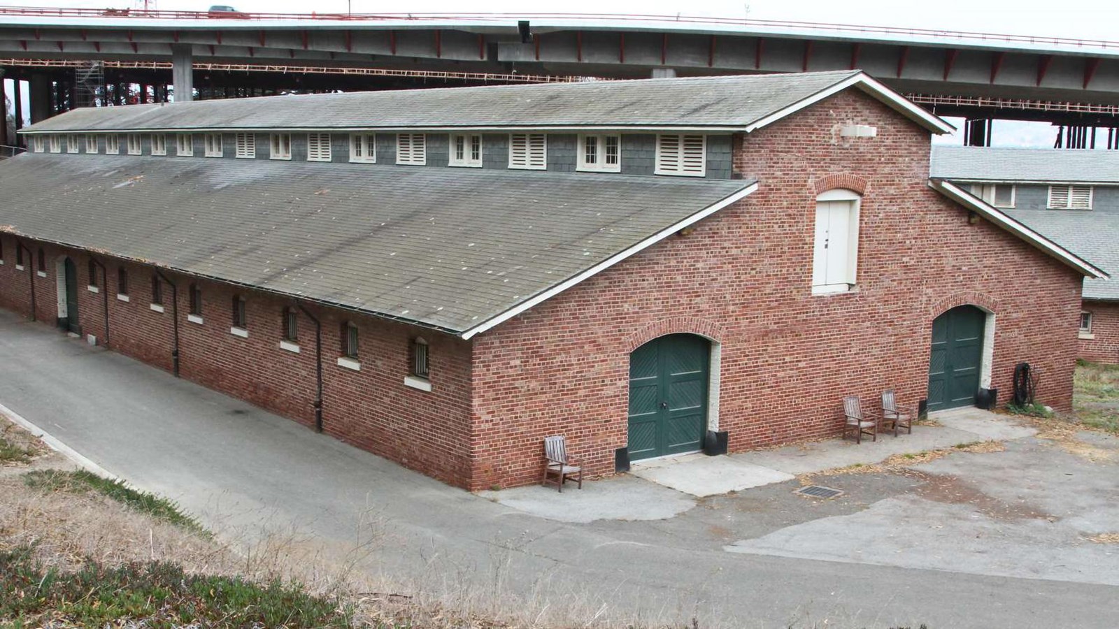 Red brick stables building with gray slate roof as they are today.