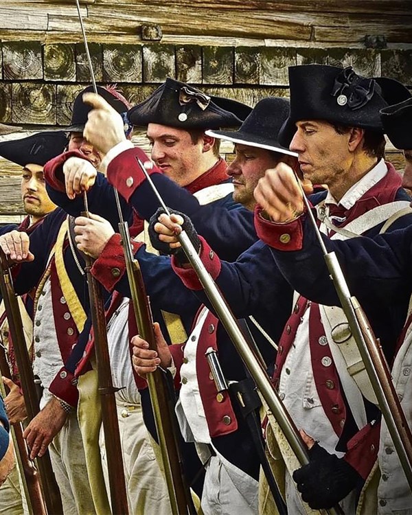 A photo of a group of men dressed as Continental Soldiers, standing in a line.