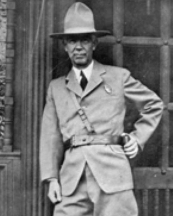 Man in a suit stands tall in front of building