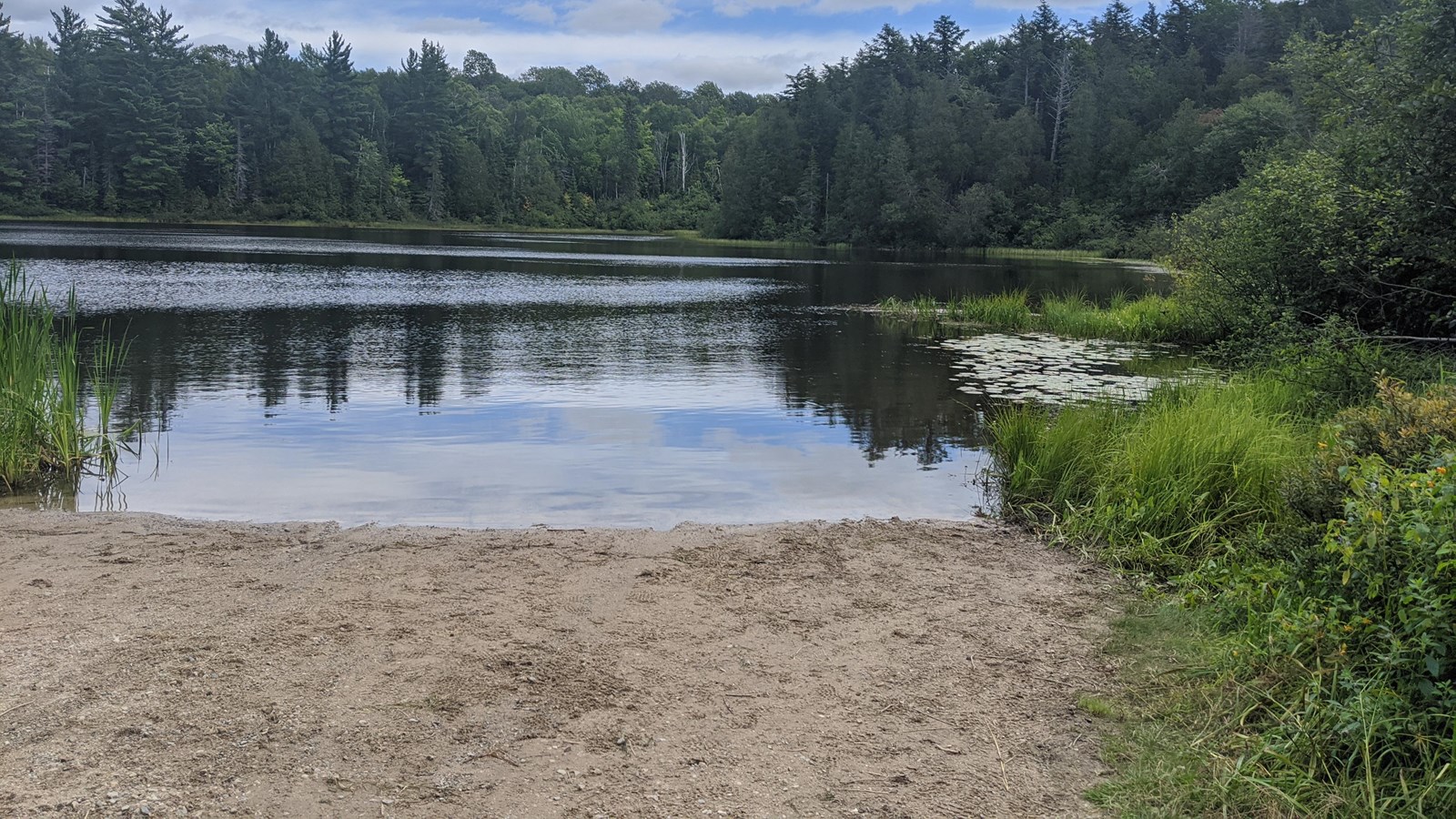 Sandy shoreline area slopes into a boat launch zone an inland lake 