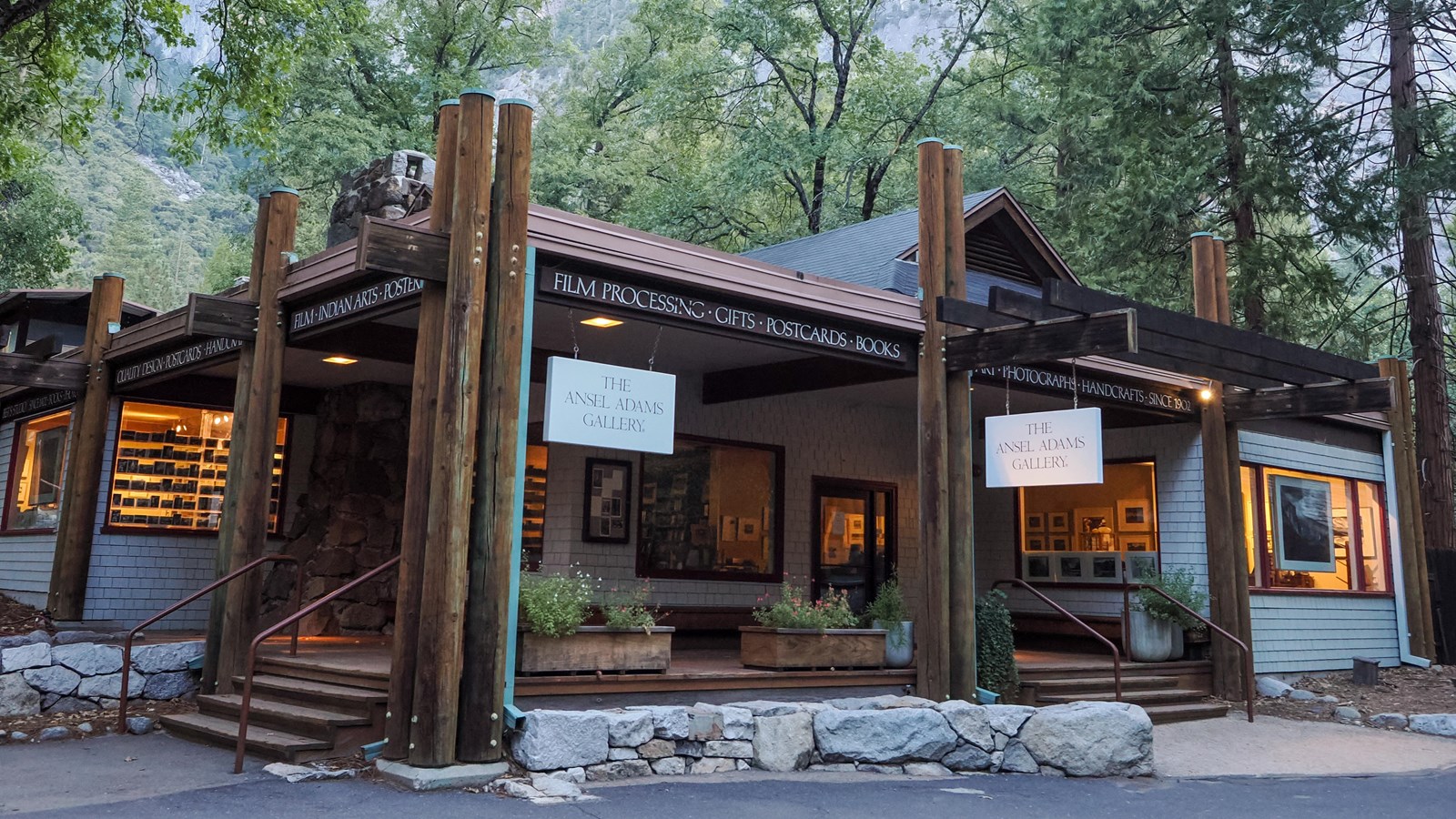 A single story building with a large covered porch and log details extending at its corners