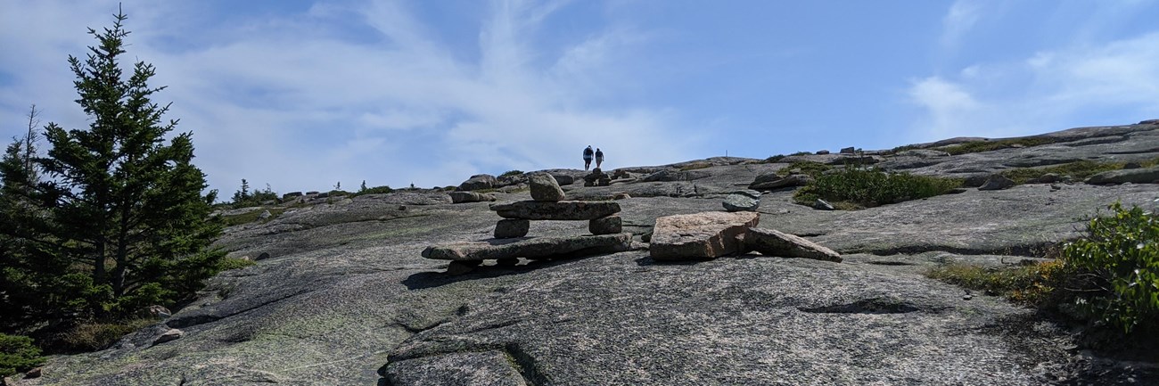 Rock cairns leading trail up exposed rock