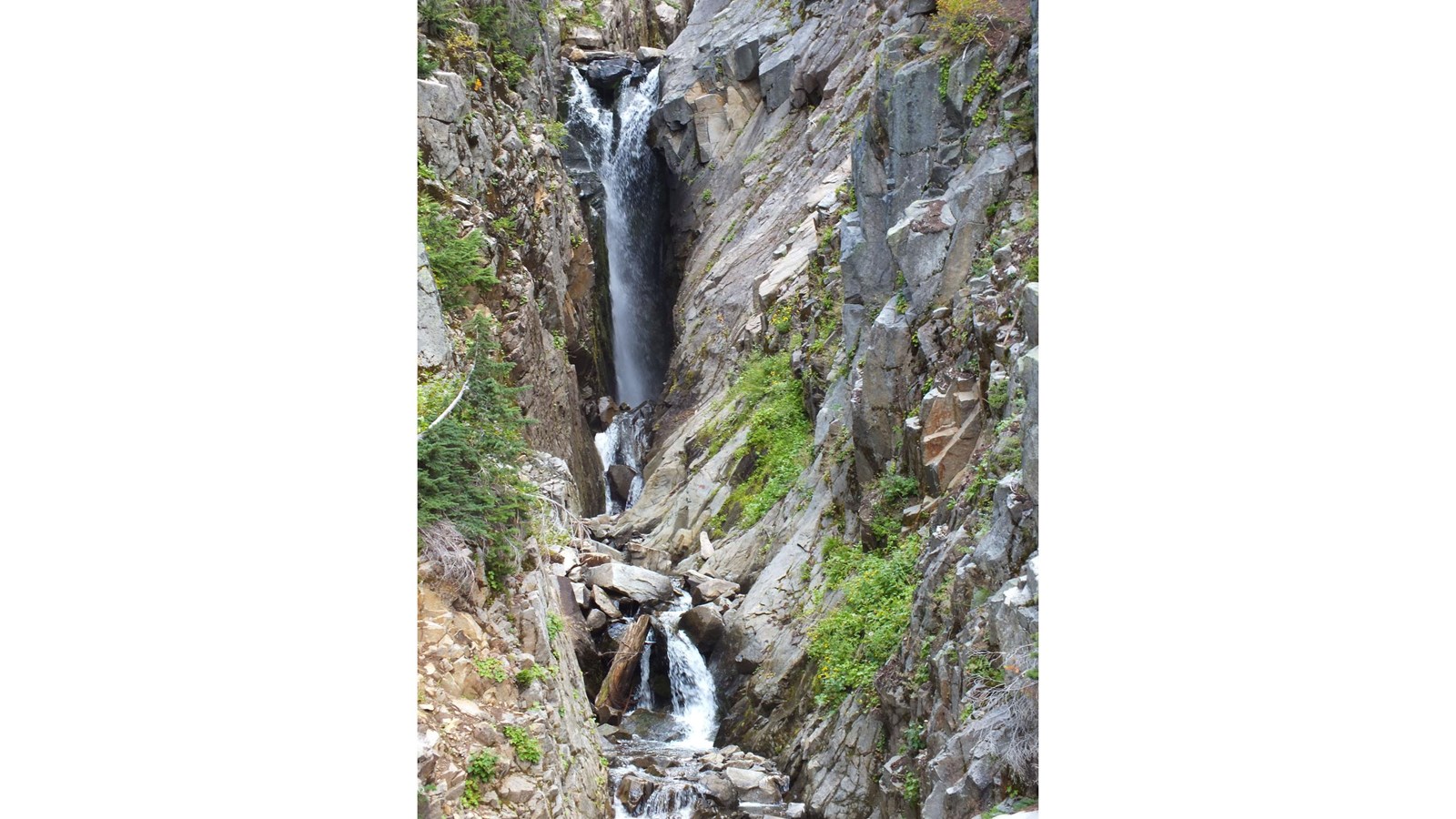 Waterfall in narrow gorge with several cascades