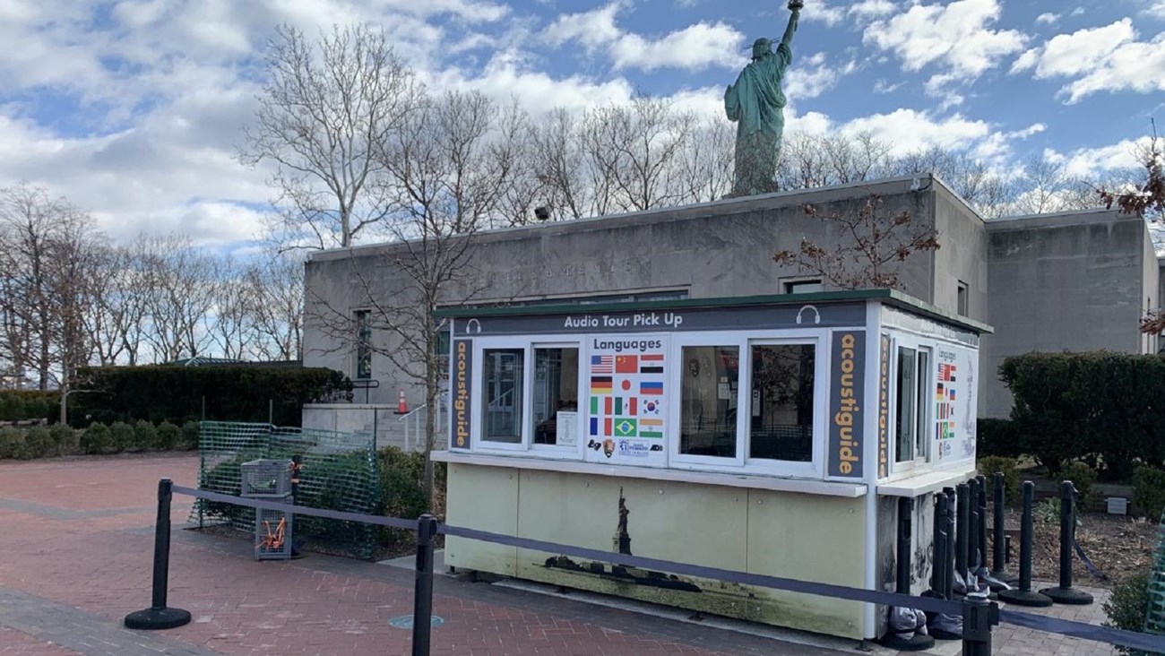 A white kiosk with large windows is available for visitors to pick up an audio guide